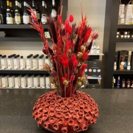 Handgemaakte rode vaas met rode droogbloemen
